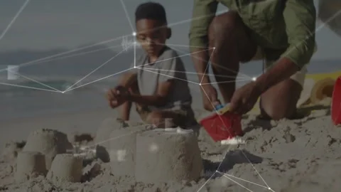 Pullback revealing dad kneeling using bucket, son shaping castles for bonding, Stock Footage 331026556