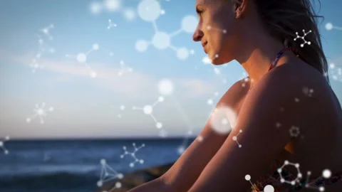 Pullback revealing woman on rocks lifting head gazing sunset, bokeh drifting Stock Footage 333336746