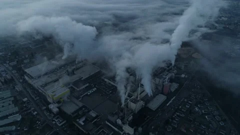 Pullback shot of a factory producing smoke revealing a misty cloudy landscape Stock Footage 147927041