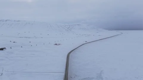Pullback From Snowy Road Winding Toward Sled Dog Camp Reflecting Remote Arctic Stock Footage 344076768