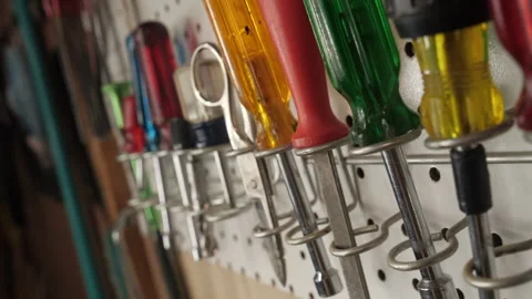 Pullback of various hand tools hanging on a pegboard in a workshop Stock Footage 197485346