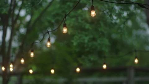 Pulled back view of string lights in a backyard Vídeos de archivo 251225807