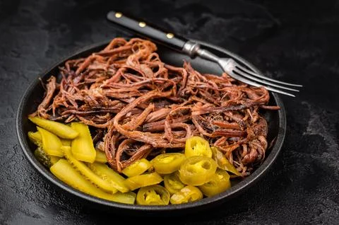 Pulled beef brisket with barbecue sauce, pickles and jalapeno in skillet on.. Stock Photos