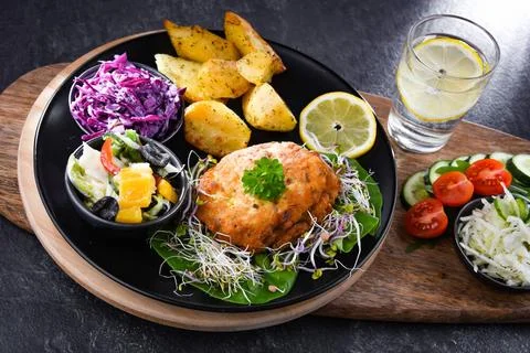 Pulled chicken cutlet coated with breadcrumbs with potatoes and vegetable ... 写真素材