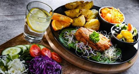 Pulled chicken cutlet coated with breadcrumbs with potatoes and vegetable sal 写真素材