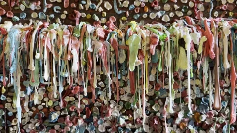 Pulled gum strands hanging from horizontal ledge on Seattle Post Alley Gum Wall Stock Footage 336279002