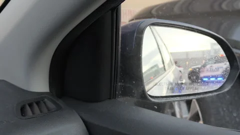 Pulled over by police seen in side view mirror 4k Stock Footage 299765482