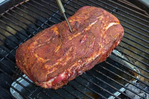 Pulled pork on barbecue grill with thermometer probe Stock Photos