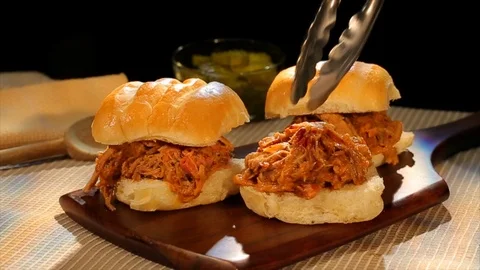Pulled pork BBQ sandwich. Assembling on hard roll. CU Video stock 102136148