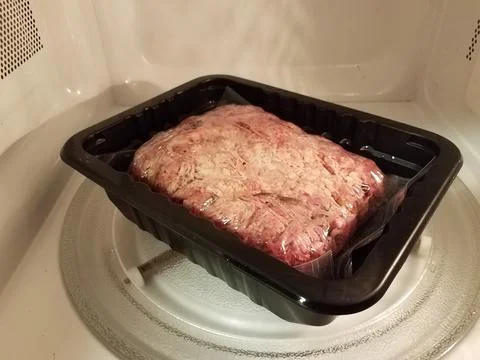 Pulled pork meat in plastic bag in microwave Stock Photos
