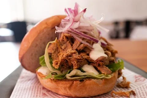 Pulled pork sandwich with lettuce, onion, and sauce Stock Photos
