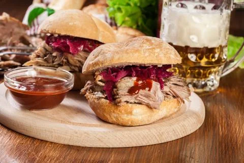 Pulled pork sandwich with red cabbage and bbq sauce on cutting board Stock Photos
