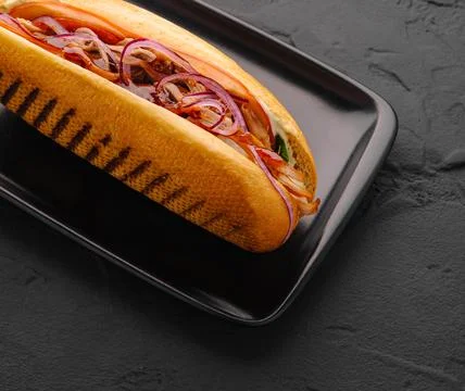 Pulled pork sandwich with red onion on black plate Stock Photos