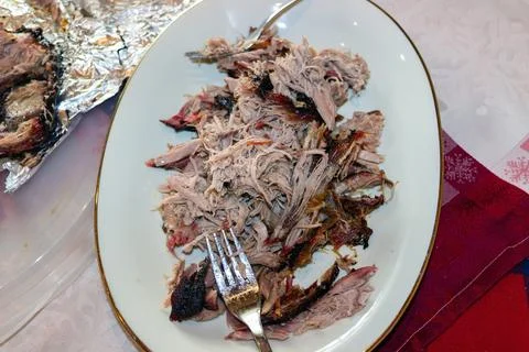 Pulled pork served on plate with fork and crispy bark Stock Photos