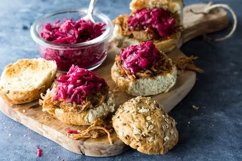 Pulled pork slider buns topped with pickled beet and red cabbage sauerkraut. Stock Photos
