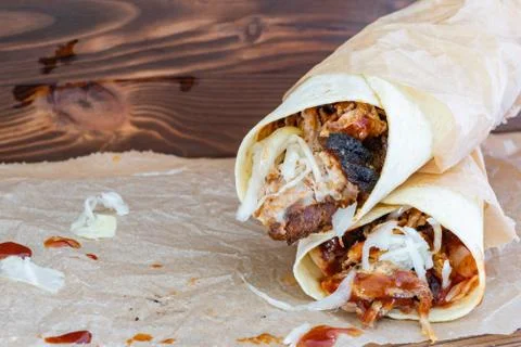 Pulled Pork Wraps with hot BBQ sauce on a wooden tabel Stock Photos