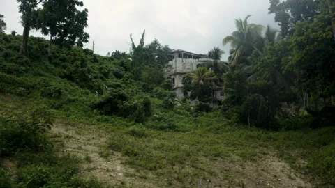 Pulling away and downhill from an  abandoned mansion at top of hill Stock Footage 152782655