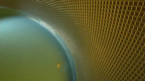 Pulling away from a DEFOCUSED metal lattice grid where the base is lit Stock Footage 162027100