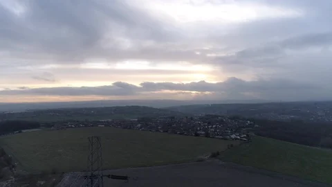 Pulling away from a pylon with a town in the distance, sunset, Drone, Yorkshire  Video stock 93420603