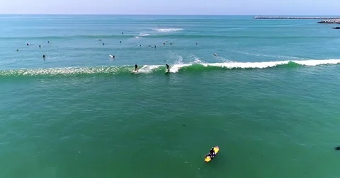 Pulling back from active surfers 4k 24fps rev 2 Stock Footage 77312309