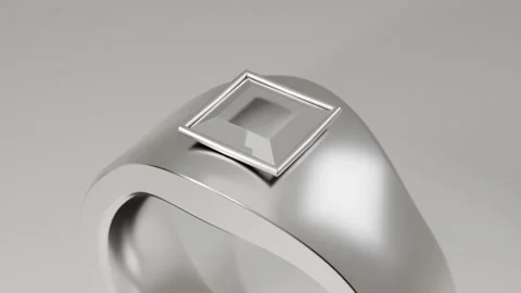 Pulling back camera revealing metal ring on gray backdrop to showcase square gem Stock Footage 339194289