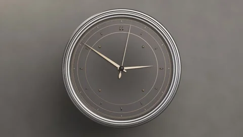 Pulling back camera revealing round analog wall clock on grey wall, hands moving Stock Footage 337505101
