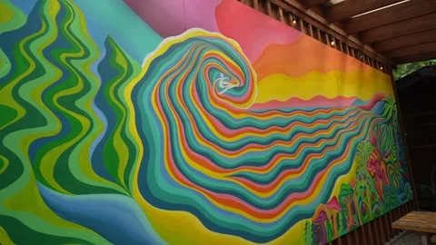 Pulling back from colorful vivid mural depicting surfer riding neon rainbow wave Stock Footage 337735654