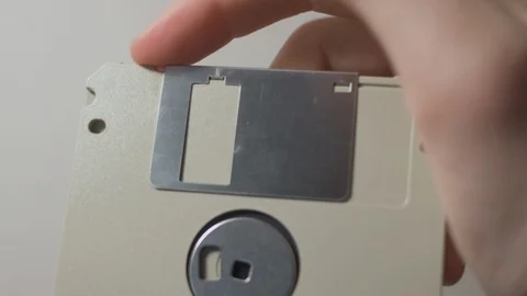Pulling back the protective cover on a 3.5" floppy diskette Stock Footage 101271891