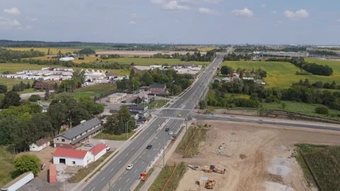 Pulling back on rural road with industrial park in distance Stock Footage 250489757