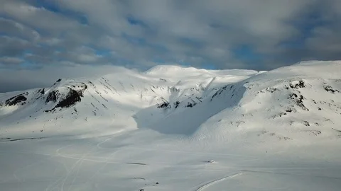 Pulling back from a snow covered mountain Stock Footage 95199878