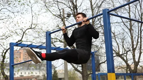 Pulling up on the Bar With His Legs Straight Exercise Young Athlete on the Bar. Stock Footage 62252765