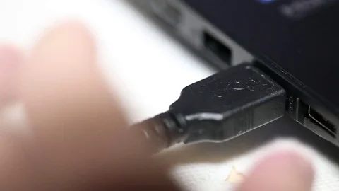 Pulling the cable out of the connector on the laptop. macro Stock Footage 82169177