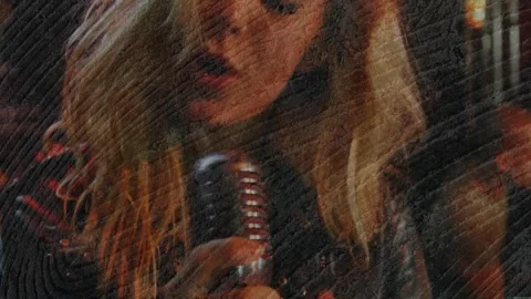 Pulling camera revealing blonde singer at club in studs gripping chrome mic Stock Footage 331404383