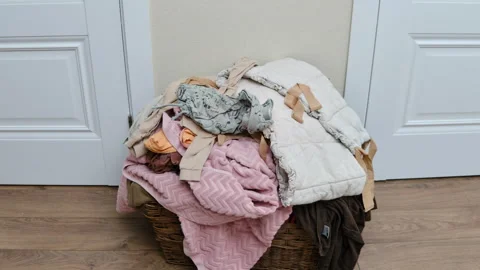 Pulling clothes out of the basket, stop motion. Sorting men s and women s Vídeos de archivo 344906603