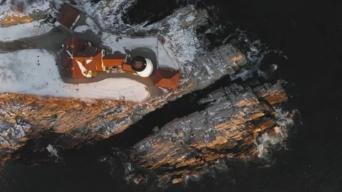 Pulling up from coastal lighthouse during winter sunrise AERIAL TOP DOWN Stock Footage 121892195