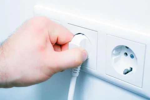 Pulling An Electrical Plug Out Of A Wall Socket To Save Energy Stock Photos