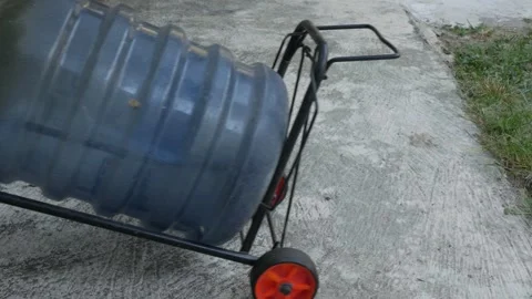 Pulling an Empty Water Jug on a Two-Wheel Hand Truck Stock Footage 342260498