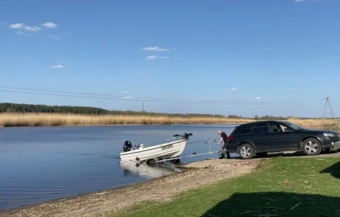 Pulling fishing boat to the car, loading a boat on boat trailer Stock Footage 240756170