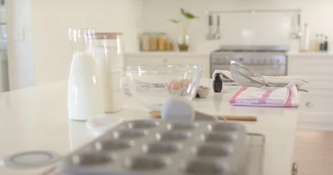 Pulling focus camera revealing muffin tin on kitchen island, showing baking prep Stock Footage 342233782
