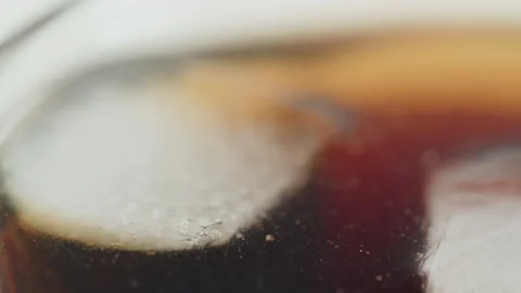 Pulling focus on ice cubes in carbonated drink 4K video Stock Footage 185157163