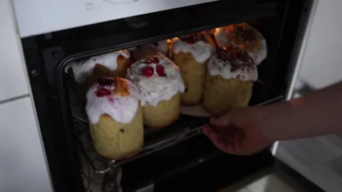 Pulling fresh Easter cakes from oven homemade sweet bread with fluffy icing fest Stock Footage 307142716