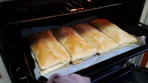 Pulling Golden Brown Puff Pastry Parcels from Hot Oven Stock Footage 325223276