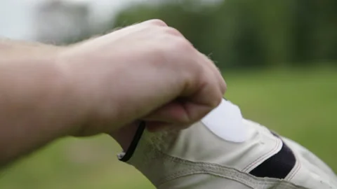 Pulling golf glove onto hand Stock Footage