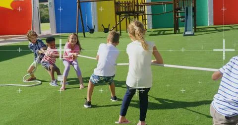 Pulling group of six children leaning back, bracing feet on playground turf, Stock Photos