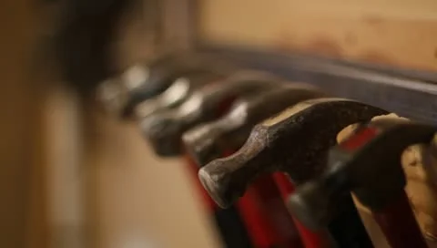 Pulling hammers off rack Stock Footage 10603756