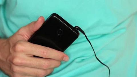Pulling a headphones cable out from the smartphone 動画素材 70515655