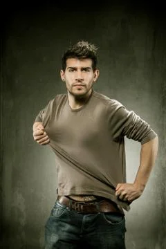 Pulling his tshirt for creating copy space Stock Photos