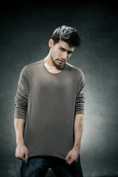 Pulling his tshirt for creating copy space Stock Photos