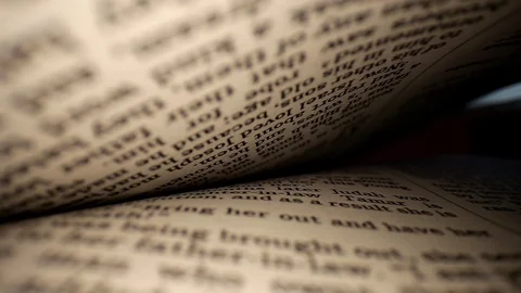 Pulling a lens out of a book centered on page. Words eye view of the Stock Footage 111295372
