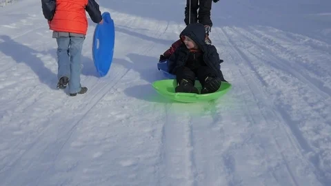 Pulling little kids back up the sledding hill Stock Footage 72254508
